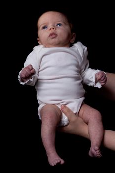 A mother raising her baby up to the light.  The photograph is side lit to add emotion to it.