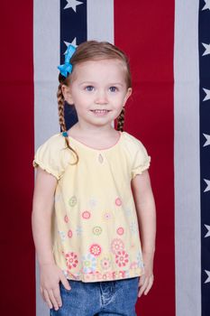 A happy American Girl standing in front of a red, white and blue background with stars.