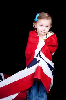 Girl with a confused look on her face.  She is drapped in a patriotic design.  There is a black background.
