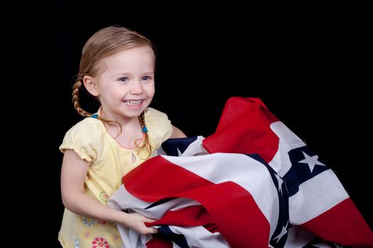 A cute girl folding/holding the American Flag