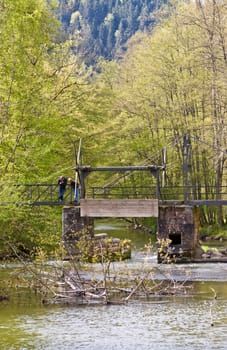 This image shows a old weir with people