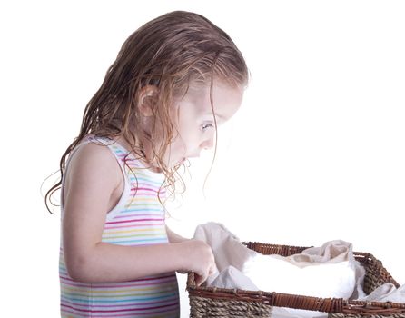 An excite young girl looking into a basket.  The basket is glowing with a ball of light or something inside of it.