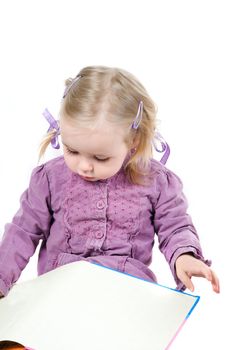 A little girl reading book in studio