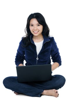 Portrait of a cheerful woman sitting on floor with a laptop.