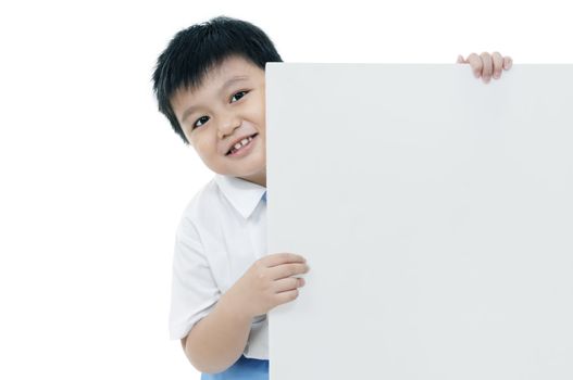 Portrait of a happy young boy holding a blank card over white background.