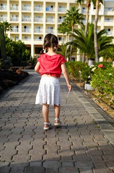 Young child walking with hotel key in her hann