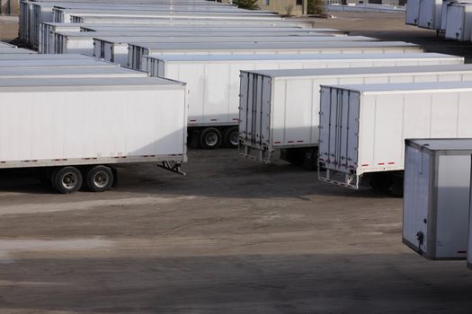 A parking lot with lots of transport trucks and trailers.