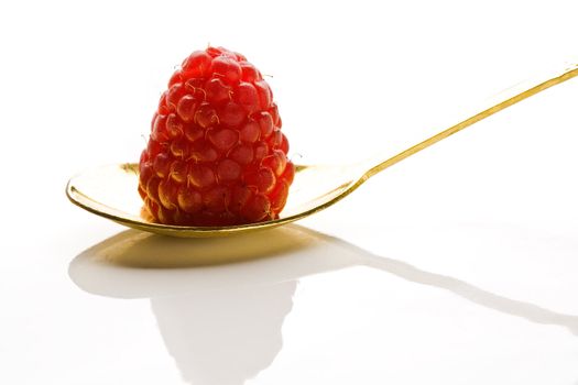 Raspberry on a gold dessert-spoon