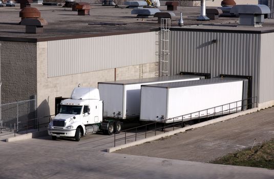 A transport truck getting loaded at a loading dock.