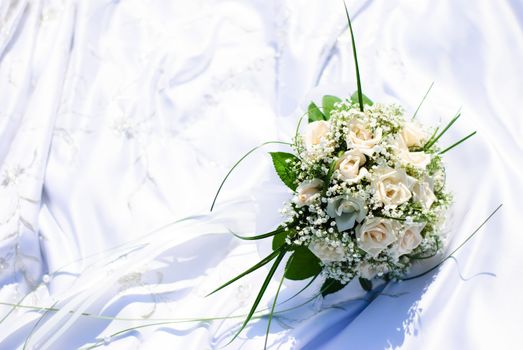 bridal bouquet of white roses on a wedding dress