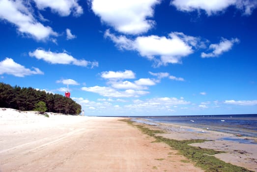 Summer clouds over sea sand and towers