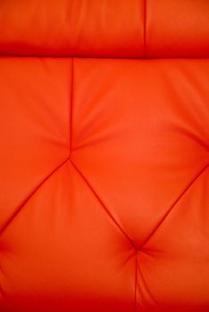 Stitchings on background of vertical red leather couch