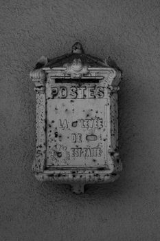 A old mailbox on a wall.