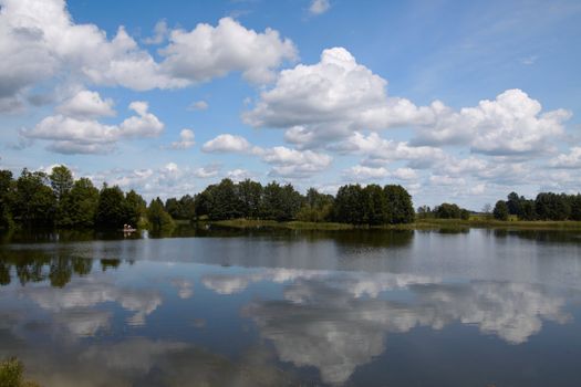 Summer landscape with a lake view, sky and clouds 