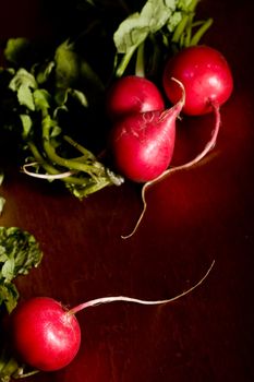 radish on a wood cutting board leaves and roots