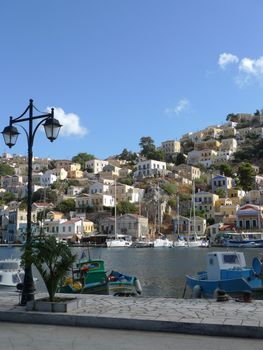 view of greek island mountain town from the marina