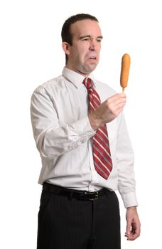 An upperclass man is disappointed about having to eat a corn dog, isolated against a white background.