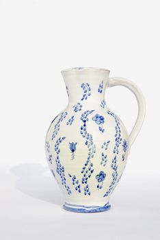 White old decorative jug painted with blue ornaments isolated on a white background