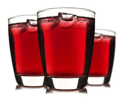 Three glasses of red fruit juice with ice on white background