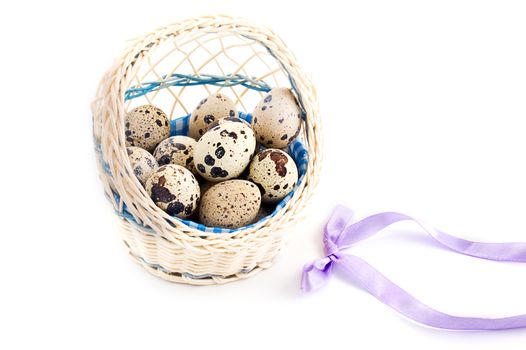 Quail eggs in basket isolated on white