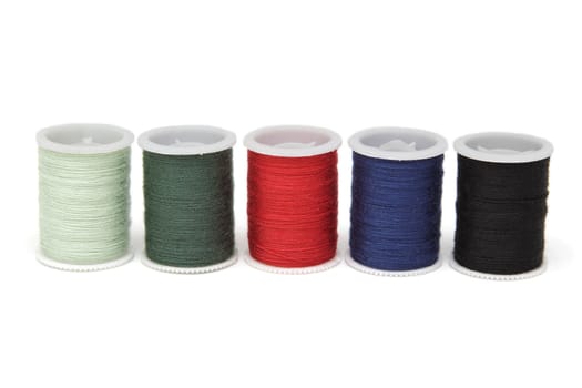 Spools of thread of various colors isolated on white background