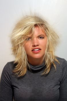 A studio close-up of a lovely young blonde who appears to be frazzled, overworked, confused, puzzled, etc.