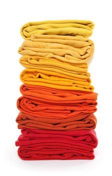 Joyful laundry. Pile of red and yellow folded clothes on white background.