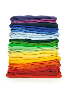 Rainbow laundry. Pile of bright folded clothes on white background.