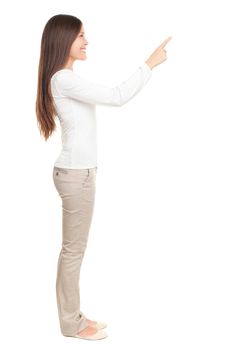 Isolated woman pointing or pushing something with index finger. Beautiful casual young woman isolated on white background in full length standing in profile.