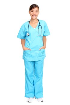 Nurse standing isolated. Young multiracial nurse or medical doctor standing isolated in full length wearing blue scrubs.