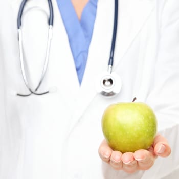 Health care. Doctor giving apple. An apple a day keeps the doctor away.