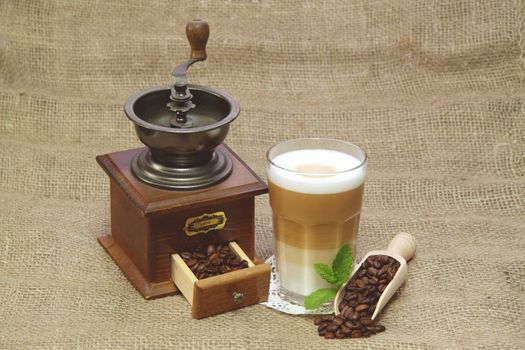 Latte Macchiato in glass with coffee grain on brown background