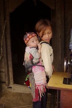 Since their very young age girls are accustomed to bear children in the back. In many families in northern Vietnam are often the elders who carry the new born.