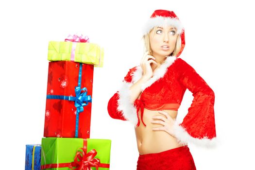 Attractive woman in the red Santa Claus costume posing near the numerous gift boxes on a white background