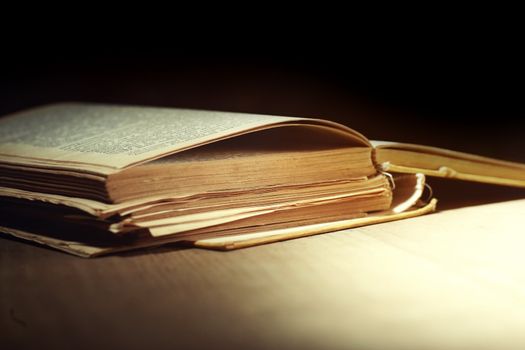 Old damaged book on the table on a dark background