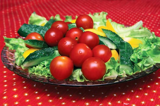 Fresh vegetables on a crystal dish on the table with a red cloth