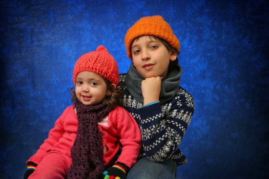Brother and sister having fun with the snow in winter outfit. Look at my gallery for more winter images