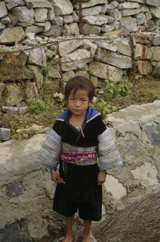 Little Boy Blue Hmong in typical costume. He was playing alone at the edge of the road
