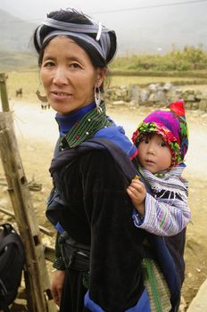 The Hmong live in small community of some houses. Hmong women have the best clothes of all minorities in Vietnam in general. Their traditional dress is two colors. Blue and black is essential. They have this particular hairstyle that ties their hair with a large blue ribbon. The silver earrings are a must.
