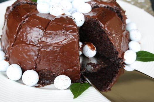 Sliced chocolate cake with mini easter eggs