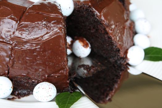 Sliced chocolate cake with mini easter eggs