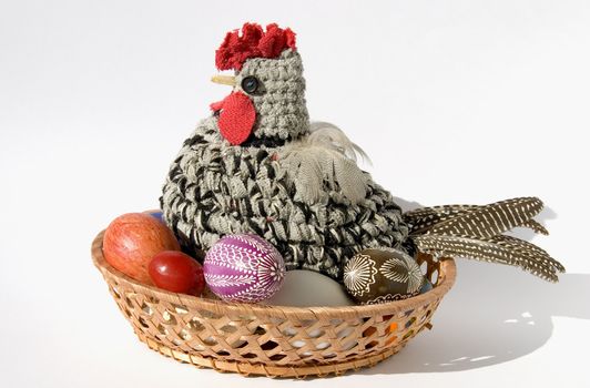 Easter chicken knitted from woollen thread with eggs in the nest isolated on a white background