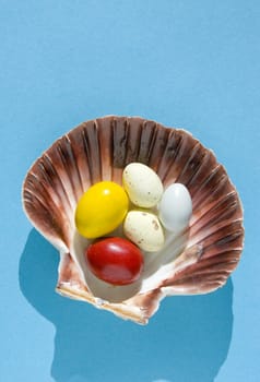 Easter eggs on the sea shell isolated on a blue background