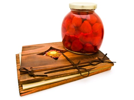 jar with red compote at ancient wooden desk against the white background