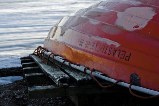 rowboat in orange in front of a sea