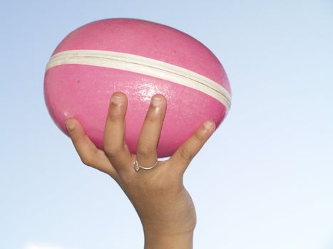 girls hand holding pink easter egg
