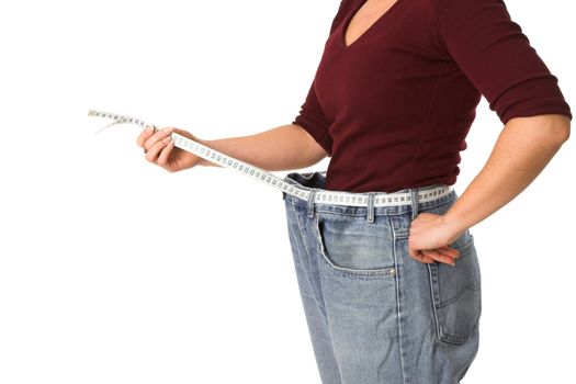 Woman holding a measuring tape around her waist showing how much weight she has lost