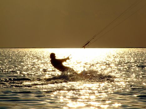 Silhouettes kitesurf on a gulf on a sunseet