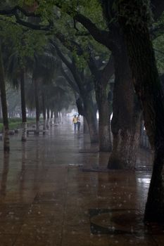Couple walking in the rain Guilin China