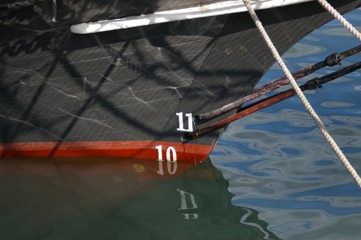 A close up of ships bow showing rigging and water depth.